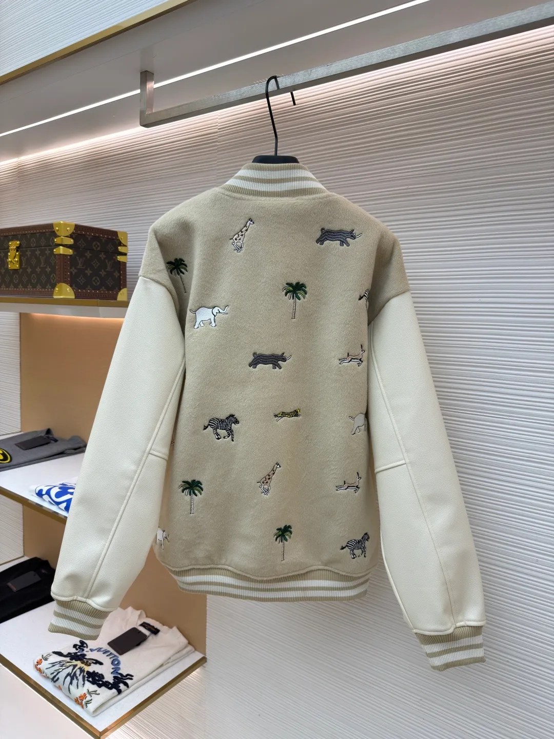 LOUIS VUITTON animal embroidered baseball uniform ●Original version: 48000 purchased and developed ●Item number: 1682284-B90 ●Fabric: cotton fabric ●Technology: embroidery production ●Color: apricot ●Version: fitted version ●Weight: about 1070 grams ●Size: 46-48-50-52 ●Description: The main body of this Louis Vuitton embroidered baseball jacket is made of high-quality wool blended fabric, which is crisp and soft. The sleeves are made of eco-friendly artificial leather with a matte texture, which contrasts with the body in terms of material and touch. The animal, palm tree and other patterns on the body of the clothing are all completed by hand-stitched embroidery technology, using multi-color embroidery threads to embroider in layers. The patterns are three-dimensional and vivid, and the stitching in the details is fine and even. The letter logo uses flat embroidery technology, and the font outline is clear and regular. The ribbed collar, cuffs and hem of the jacket are made of high-elastic knitted fabric, which will not loosen easily after being worn for a long time. The metal snaps on the placket are custom-made hardware with a thick texture and anti-oxidation. The overall tailoring is a loose oversize version, and the splicing uses hemming stitching technology, and the lines are smooth and smooth. Every craft detail is in line with the brand's luxury product production standards, creating a ready-to-wear garment that has both a sense of design and practical wearability. The overall wiring is straight and delicate, the fabric is comfortable and soft, and the color is consistent without color difference. It can be matched with the same style to create a fashionable look and control various occasions. Customized accessories, complete with three standards, same style for men and women!